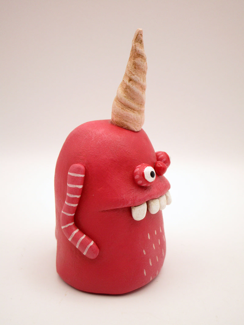 Pink monster with twisted single horn and wacky teeth