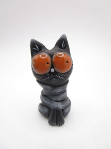 Little Halloween black cat mummy with huge orange eyes