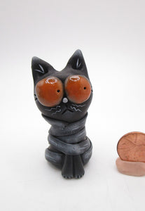 Little Halloween black cat mummy with huge orange eyes