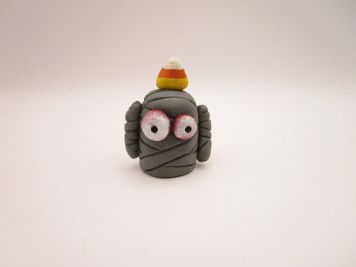 Halloween folk art small mummy man a candy corn on its head