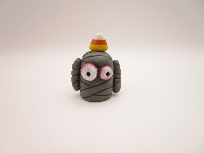Halloween folk art small mummy man a candy corn on its head