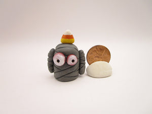 Halloween folk art small mummy man a candy corn on its head
