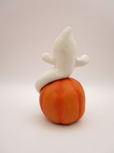 Halloween folk art cute ghost sitting on surprised pumpkin