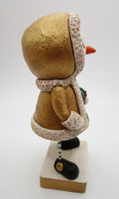 Christmas snowman wearing golden shimmer jacket holding holly sprig