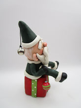 Christmas folk art Santa sitting on a present