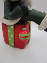 Christmas folk art Santa sitting on a present