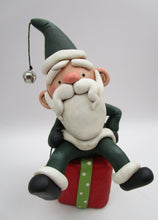 Christmas folk art Santa sitting on a present
