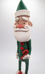 Christmas folk art Santa in green suit with candy cane