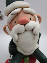 Christmas folk art Santa sitting on a present