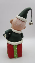 Christmas folk art Santa sitting on a present