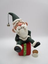 Christmas folk art Santa sitting on a present