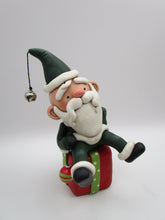 Christmas folk art Santa sitting on a present