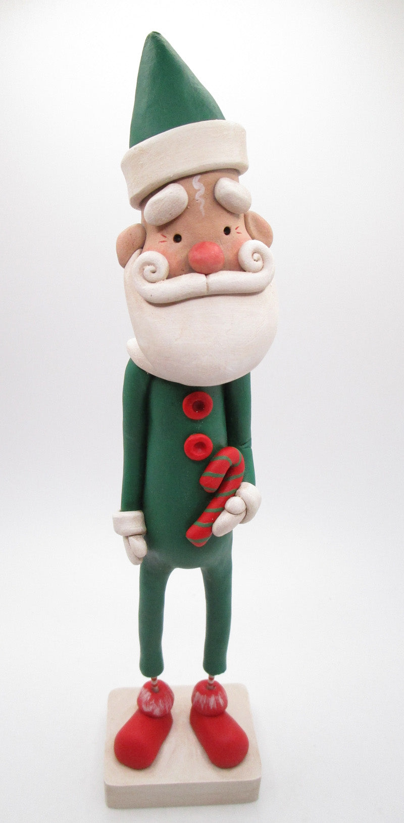 Christmas folk art Santa in green suit with candy cane