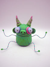 Monster folk art green twisty horned monster with bendable arms and legs