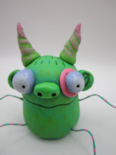 Monster folk art green twisty horned monster with bendable arms and legs