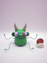 Monster folk art green twisty horned monster with bendable arms and legs