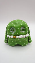 Lime green monster with wacky teeth and swirl inset eyes