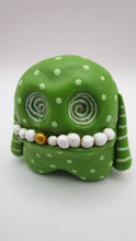 Lime green monster with wacky teeth and swirl inset eyes