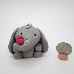 Valentines day elephant holding a pink heart with his trunk