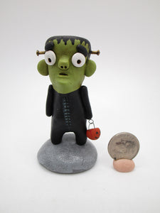 Halloween little Frankenstein with tiny pumpkin candy bucket
