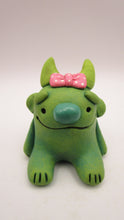 Monster character small green with pink bow