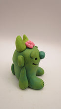 Monster character small green with pink bow