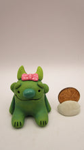 Monster character small green with pink bow