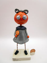 Halloween folk art pumpkin girl holding Halloween lollipop
