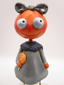 Halloween folk art pumpkin girl holding Halloween lollipop