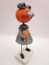 Halloween folk art pumpkin girl holding Halloween lollipop