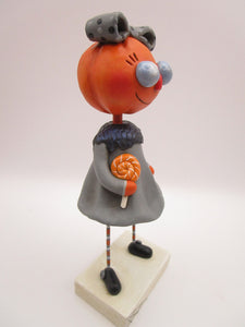 Halloween folk art pumpkin girl holding Halloween lollipop