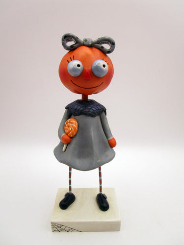 Halloween folk art pumpkin girl holding Halloween lollipop