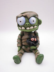 Halloween sitting Mummy man with BAT tugged in arm