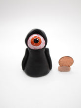 Halloween eyeball caped creature with orange bloodshot eye