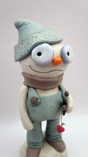 Christmas folk art snowman in muted teal overalls with heart stick