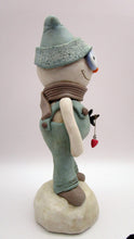 Christmas folk art snowman in muted teal overalls with heart stick