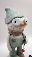 Christmas folk art snowman in muted teal overalls with heart stick