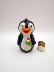 Christmas folk art penguin with a fish in hand