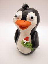 Christmas folk art penguin with a fish in hand