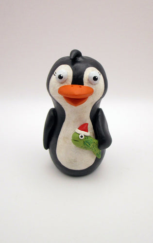 Christmas folk art penguin with a fish in hand