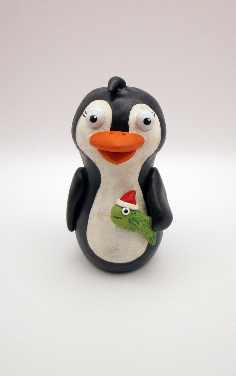 Christmas folk art penguin with a fish in hand