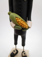 Thanksgiving folk art Pumpkin man wearing Pilgrim attire with corn
