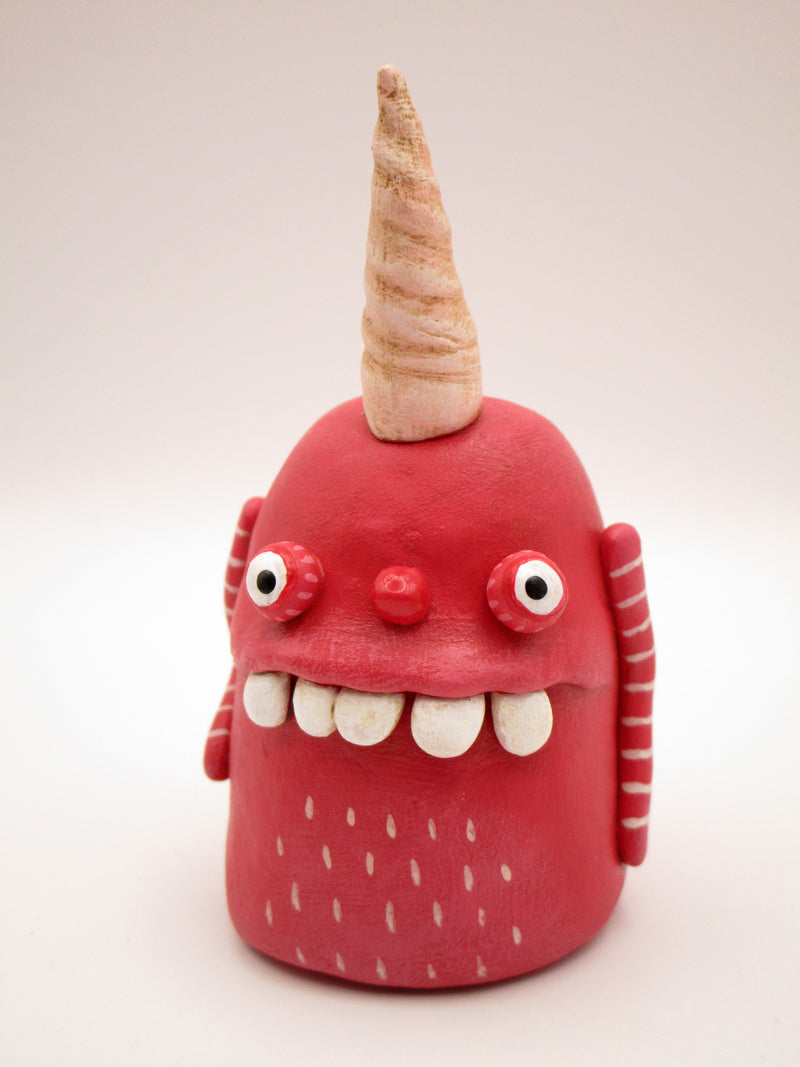 Pink monster with twisted single horn and wacky teeth