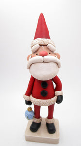 Traditional Christmas Santa Claus with detailed ornament in hand