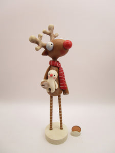 Christmas folk art reindeer with wood legs holding snowman