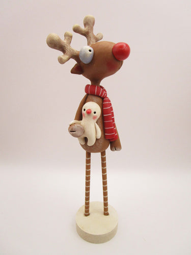 Christmas folk art reindeer with wood legs holding snowman