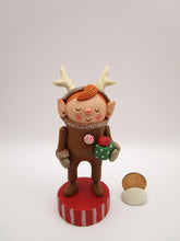 Christmas folk art elf in reindeer suit with little gift in hand
