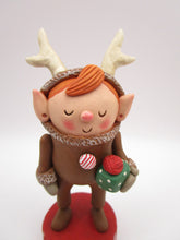 Christmas folk art elf in reindeer suit with little gift in hand