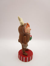 Christmas folk art elf in reindeer suit with little gift in hand
