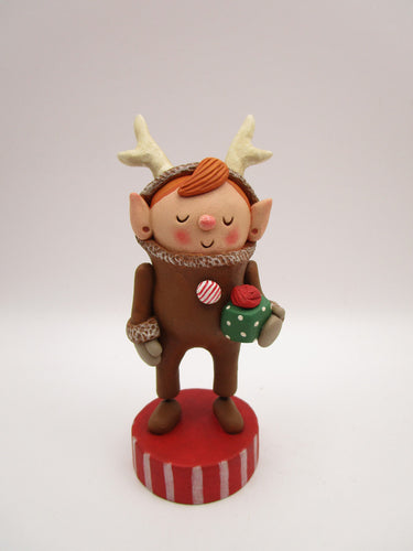 Christmas folk art elf in reindeer suit with little gift in hand